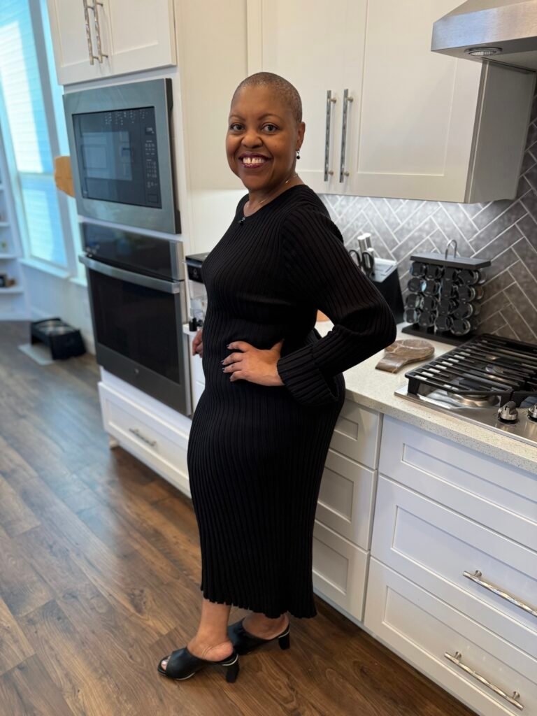 Carmela after, smiling in her kitchen