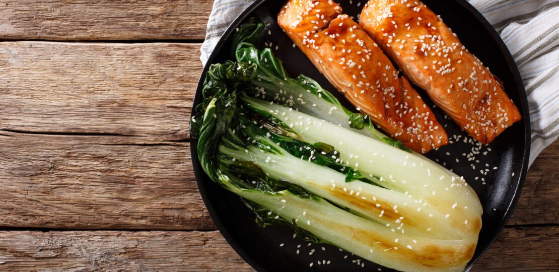 glazed salmon fillet with sesame seeds and roasted cabbage bok choy close up. horizontal top view